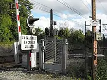 Vue d'une barrière du passage à niveau n° 159 et d'un portillon d'accès à la voie.