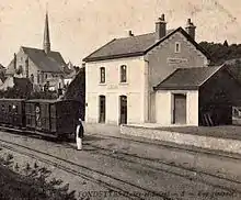 Carte postale figurant l'ancienne gare et la ligne exploitées par la compagnie CFD Réseau d'Indre-et-Loire nord, ici à Fondettes. En arrière-plan : l'église paroissiale.