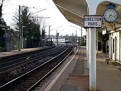 Une rame inox de banlieue tractée par une BB 17000 entre en gare, à destination de Paris.