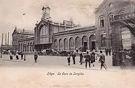 Carrosses et foule devant la gare.