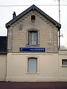 Panneau du nom de la gare sur un bâtiment.