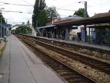 Le bâtiment de la gare et la passerelle vus depuis le quai pour Versailles.