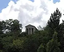 Vue d'un temple au centre d'un bois, en haut d'un coteau.