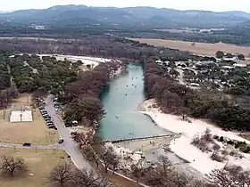 Vue aérienne d'une rivière bordée d'arbres et d'une plage de sable