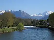 Photo montrant un cours d'eau et des montagnes enneigées.