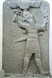 Stèle hittite tardive, basalte, 700-750 av. J.-C. Le dieu de la tempête Tysup tient une hache et un faisceau d'éclairs. Au-dessus du dieu, disque solaire ailé.