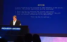Gabe Newell présentant l'écran bleu de la mort de GLaDOS au Game Developers Conference de 2010.