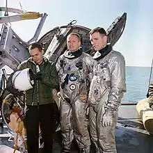 Armstrong et Scott en combinaison argentée posant près de leur capsule.