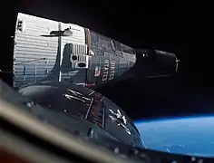 Photographie en couleur d'un vaisseau spatial vu d'un autre, à quelques mètres d'éloignement.