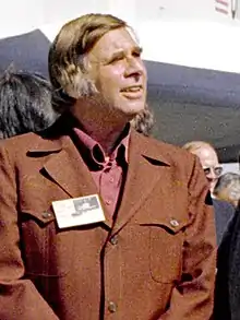 Un homme en uniforme brun regardant à droite.