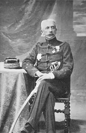 A portrait of General Lyautey in military uniform, seated at a small table