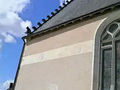 Vue d'une frise sur un mur, ornée de blasons autrefois peints