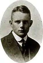Portrait en buste noir et blanc d'un jeune homme en costume.
