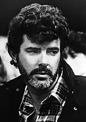photo en noir et blanc du visage d'un homme, George Lucas, portant la barbe
