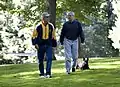 Le président George W. Bush et son Chief of Staff Josh Bolten marchant avec le chien du président Barney (en), à Camp David, le 21 juillet 2007.