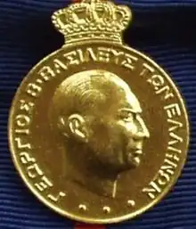 Médaille dorée montrant le visage de profil d'un homme.