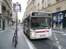 Photographie d'un arrêt de bus matérialisé par un totem, devant lequel est stationné un bus numéroté 91 à destination de la gare Saint-Paul.