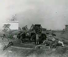 Photographie en noir et blanc d'une batterie d'artillerie