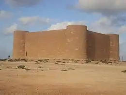 Fortification massive et cubique dans le désert qui sert de mémorial allemand.