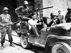 Soldats de la 92e division encadrant un prisonnier allemand.