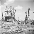 À la fin de la Seconde Guerre mondiale, en Allemagne occupée par les alliés, photographie en noir et blanc d'un gazomètre détruit par les bombardements et dont il ne reste que la carcasse.