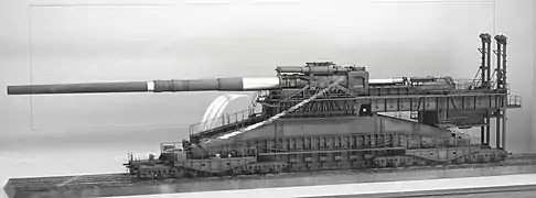 Une ogive dépourvue de sa cloche, tête percutante et explosive, et une douille du canon Krupp de 800 mm.
