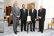 Photographie de quatre hommes en costume dans un bâtiment