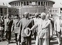 À l'aéroport de Băneasa en juin 1960, le dirigeant communiste roumain Gheorghe Gheorghiu-Dej (premier plan à gauche) et le dirigeant soviétique Nikita Khrouchtchev (premier plan à droite), accompagnés de Nicolae Ceaușescu (le successeur de Gheorgiu-Dej, juste à la droite de celui-ci) à la clôture du 7e congrès du Parti ouvrier roumain (ultérieurement renommé Parti communiste).