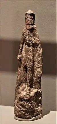 Figurine-plaque en terre cuite peinte, représentant un personnage debout, sans doute Gilgamesh, piétinant la tête de Humbaba après l'avoir vaincu. Début du IIe millénaire av. J.-C., Tell Asmar (?), Musée du Louvre.