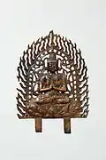 sculpture en métal présentant un bouddha assis en prière, entourée en flammèches.