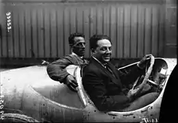 Photo d'un homme et de son passager prenant la pause au volant d'une voiture.