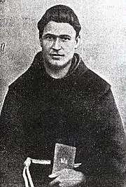Gravure ou photo noir et blanc d'un homme en tenue franciscaine avec bure foncée et cordon blanc, un livre à la main