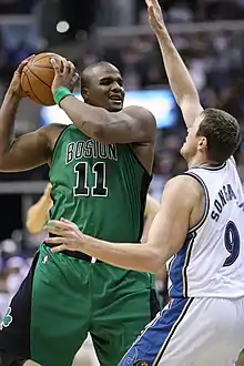 Le joueur des Celtics de Boston Glen Davis (no 11) protégant le ballon de basket-ball du défenseur des Wizards de Washington Darius Songaila (no 9)