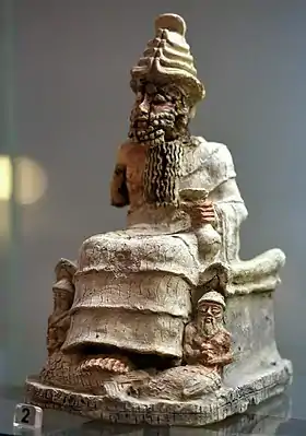 Statuette en terre cuite du dieu Enki/Ea sur un trône, une coupe à la main. Début du IIe millénaire av. J.-C. Musée national d'Irak.