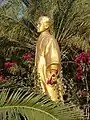Statue dorée dans des fleurs.