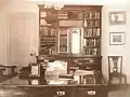 Intérieur avec bureau chaise et bibliothèque.