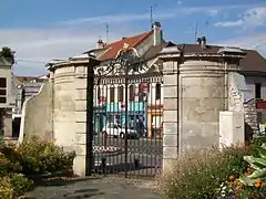 La grille du parc de l'Hôtel-de-Ville à l'est, rue de Paris.