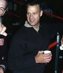 Photographie de Gordie Howe en pull et avec un verre à la main