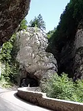 Route en encorbellement passant au travers d'une arche rocheuse par un tunnel