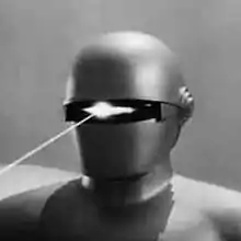 Photo noir et blanc d'un robot projetant un rayon laser avec son œil unique.