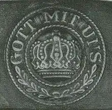 Inscription sur le fermoir d'une ceinture d'un uniforme datant de la Première Guerre Mondiale.