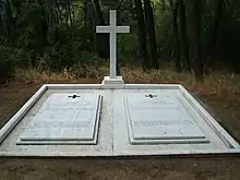 Photographie d'une double pierre tombale ornée d'une croix latine.