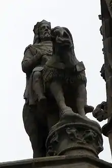 Vue de trois-quart face d'un roi sur son destrier sur le haut d'une colonne.