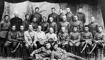 Photo noir et blanc d'un groupe de 26 officiers en uniforme, posant sur quatre rangs.