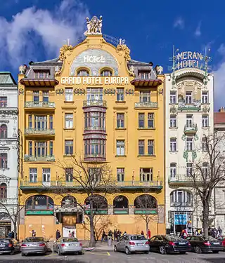 La façade sur rue d'un bâtiment art nouveau, à dominante jaune, à cinq étages.
