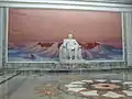 Statue de Kim Il-sung avec une peinture du mont Paektu en arrière-plan.
