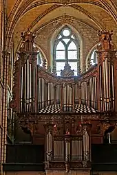 Photographie d'un grand orgue de tribune placé devant les verrières de la façade ouest