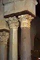 Vue partielle de trois colonnes à chapiteaux corinthiens, lesquels sont surmontés de tablettes en bois. Ces dernières séparent les chapiteaux des impostes.