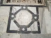Photographie d'un décor géométrique du pavement de la cour. Il est formé d'un placage de marbres noir et blanc.