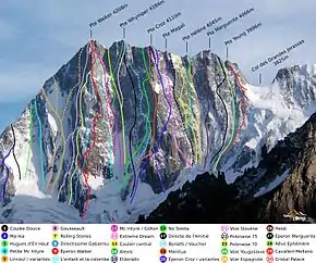 Paroi rocheuse verticale partiellement couverte de neige avec le tracé en couleur de trente voies d'ascension différentes